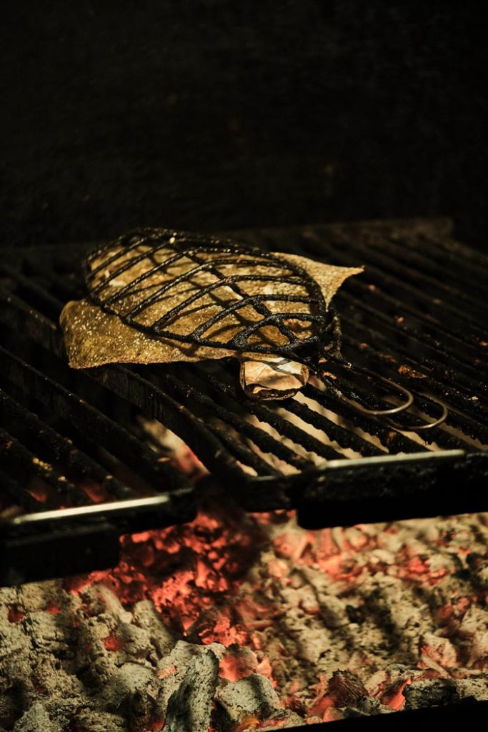 elkano fish grilling over charcoal